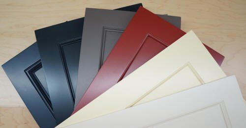 A bunch of different colored doors are stacked on top of each other on a table.