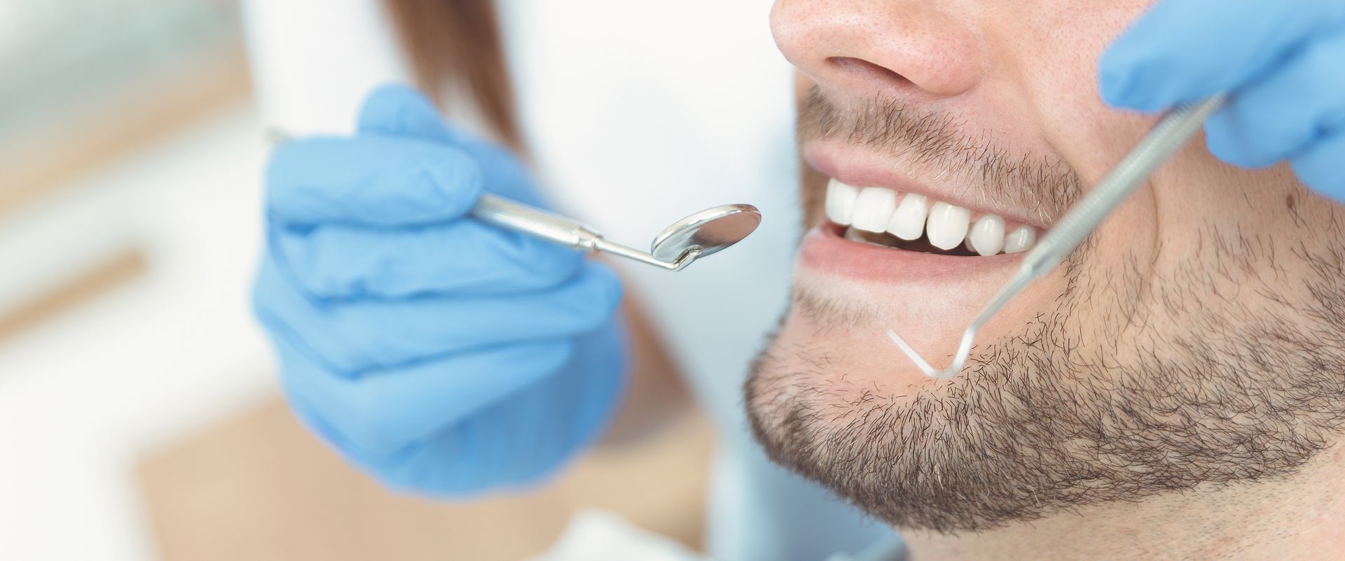 Close-up of a patient receiving a General Dentistry checkup with a dental mirror
