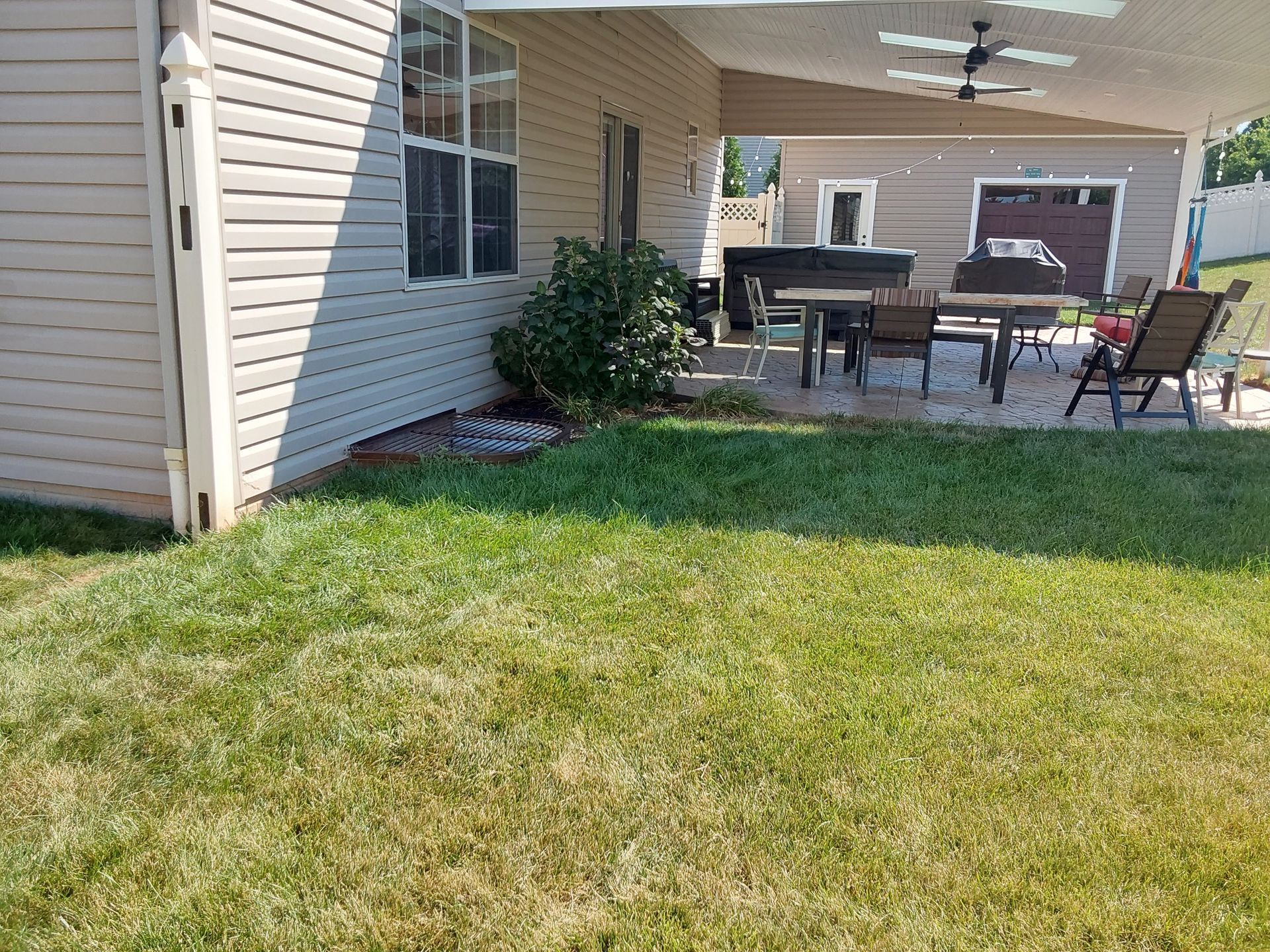 a house with a covered patio and a table and chairs in the backyard