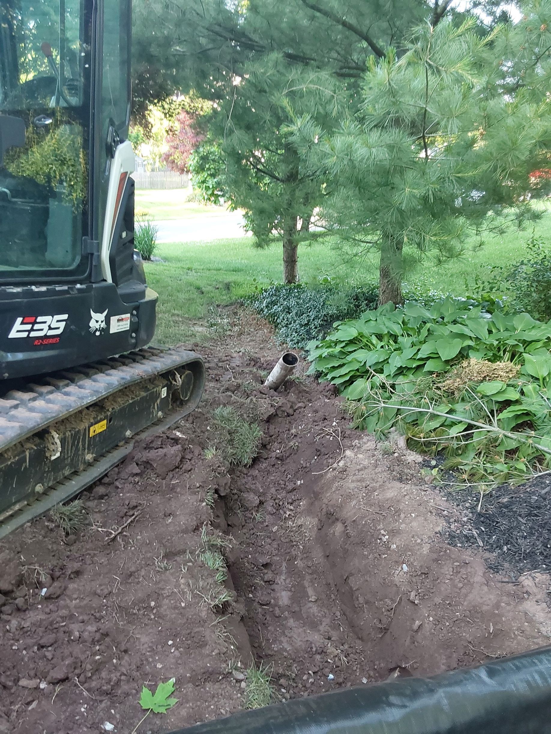 a bulldozer is digging a hole in the ground in a yard
