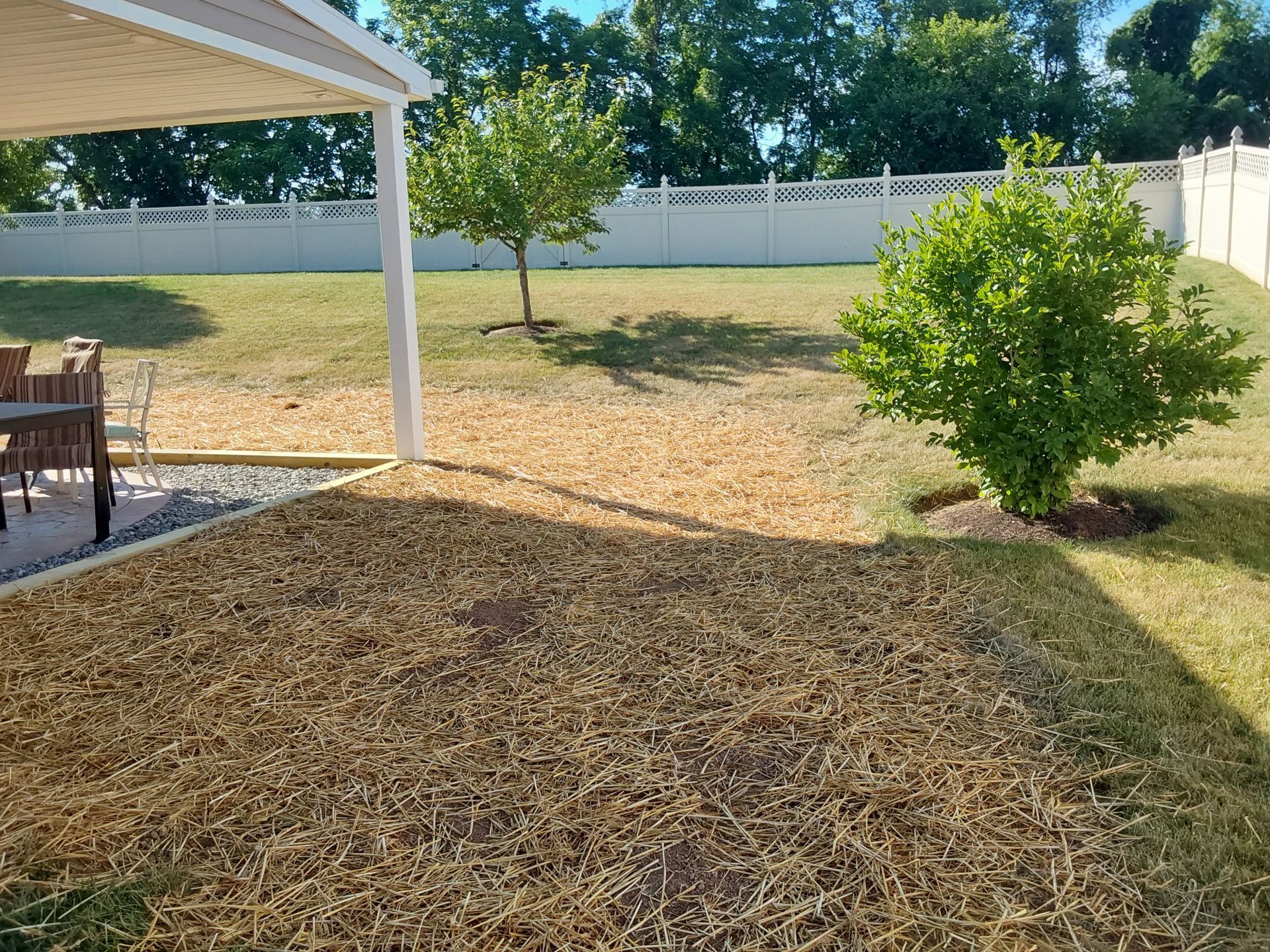 a backyard with a patio and a white fence