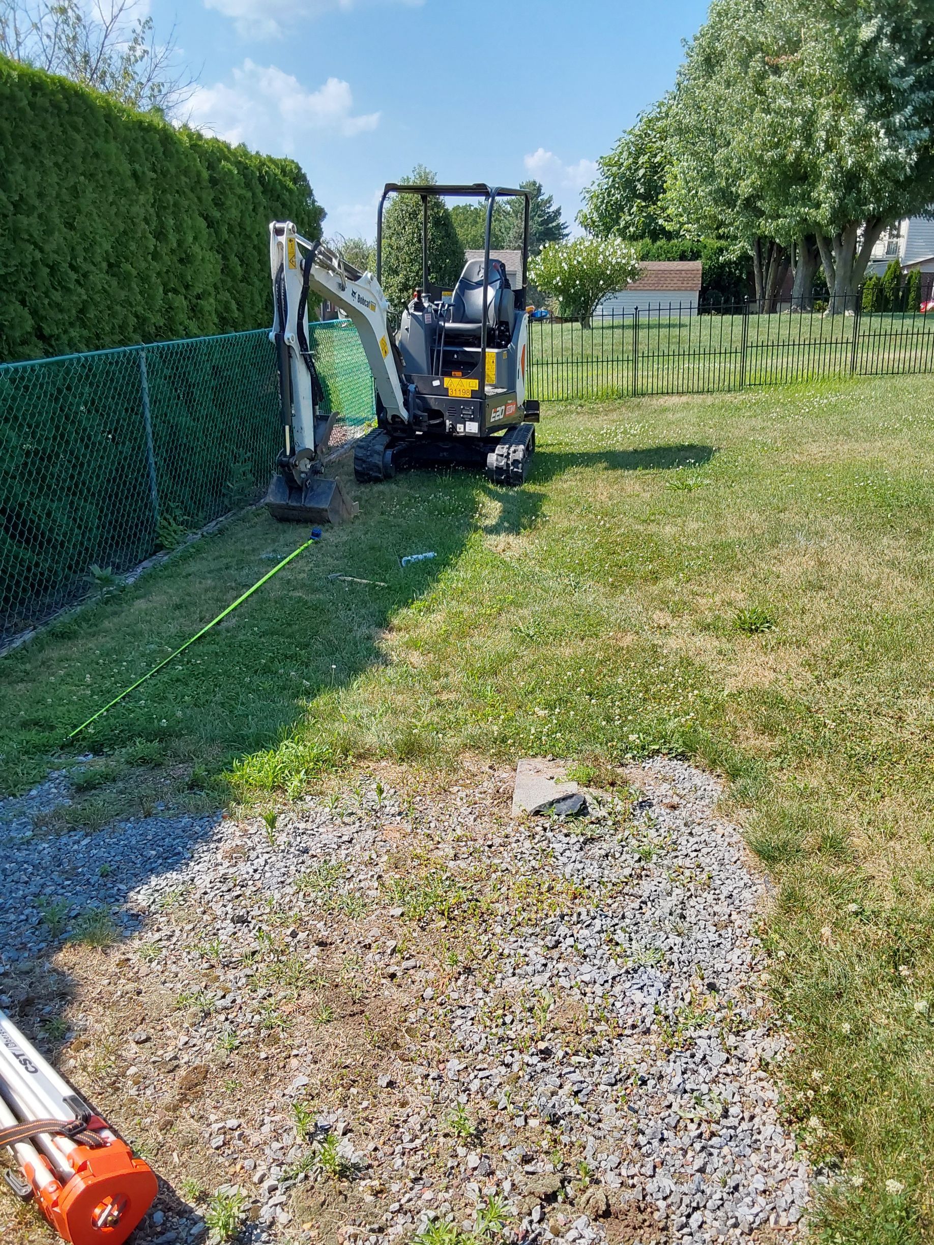 a small excavator is sitting in the middle of a grassy field