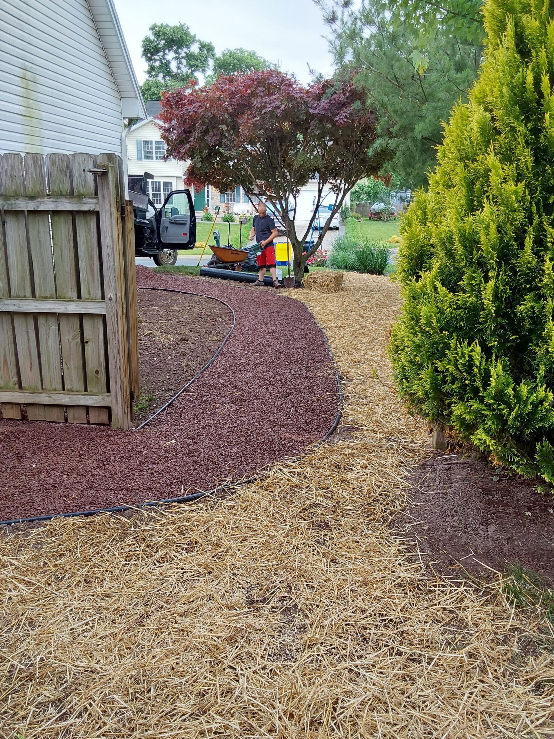 a lawn mower is sitting in a yard next to a wooden fence