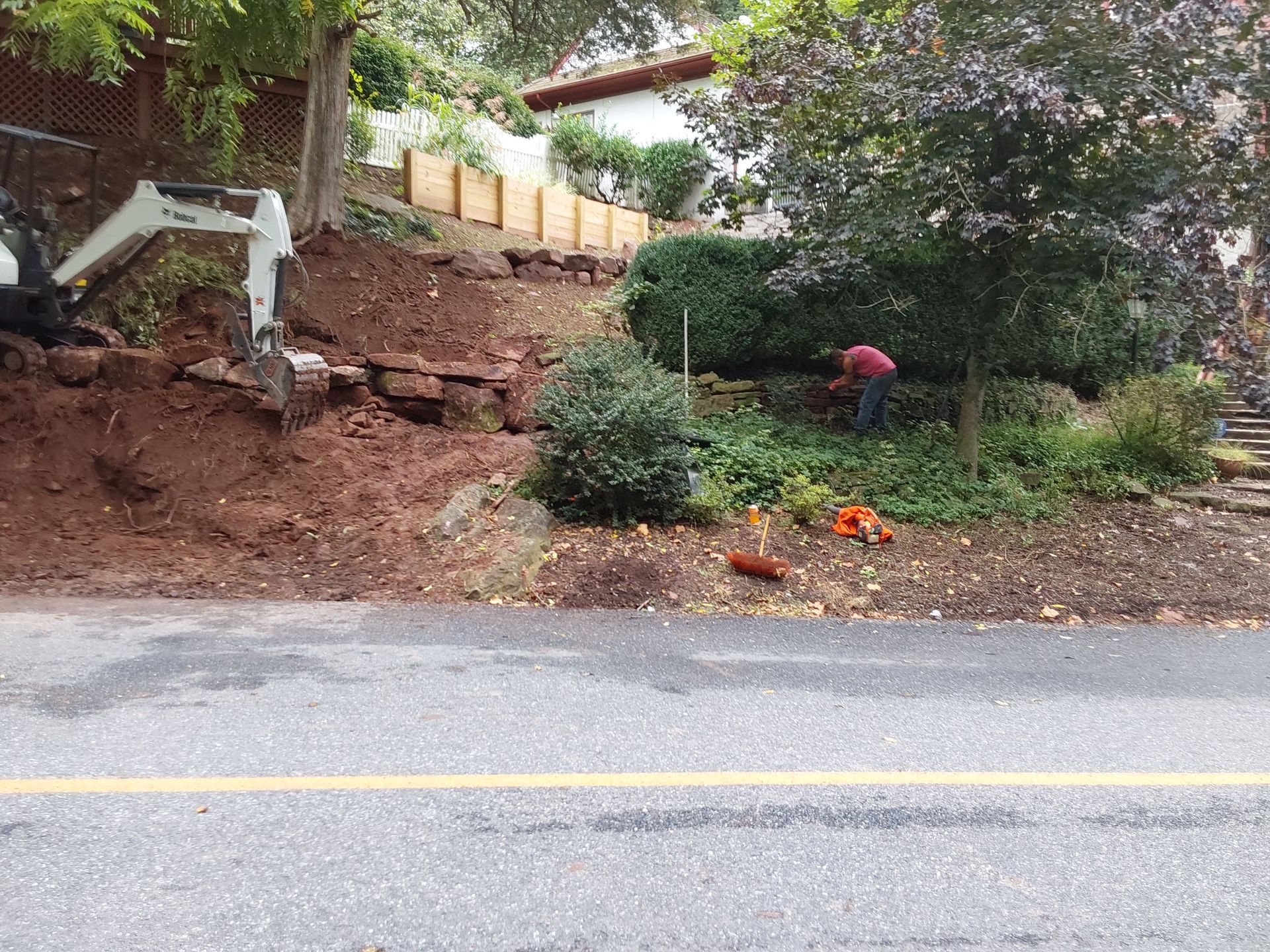 a man is working in a garden next to a road