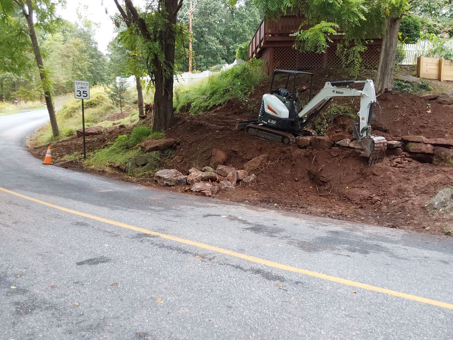 a small excavator is sitting on the side of a road