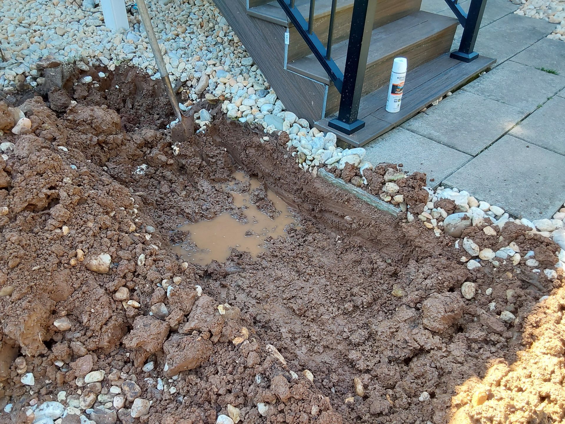 a pile of dirt and rocks on a sidewalk next to stairs