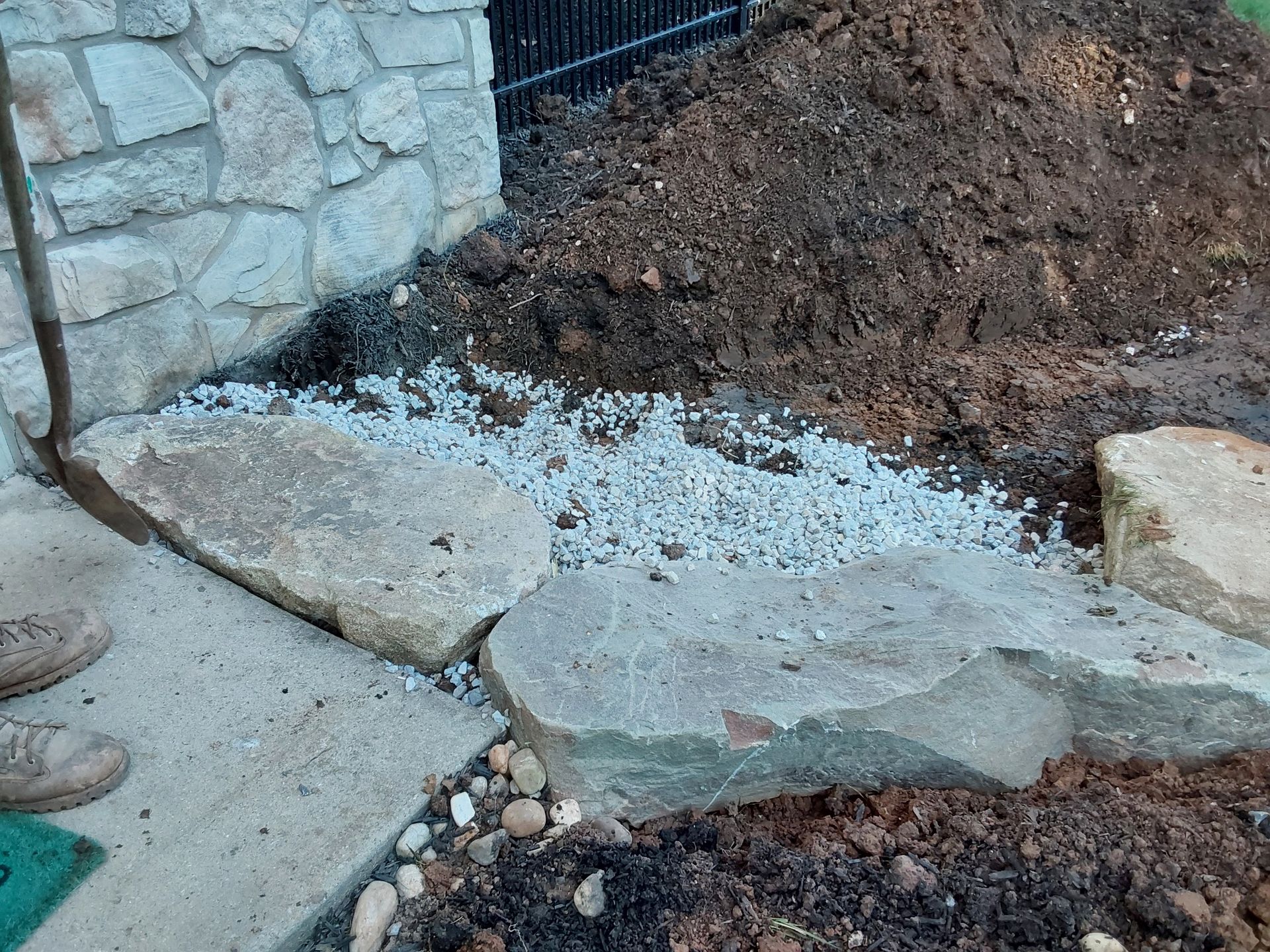 a shovel is sitting on a sidewalk next to a pile of dirt