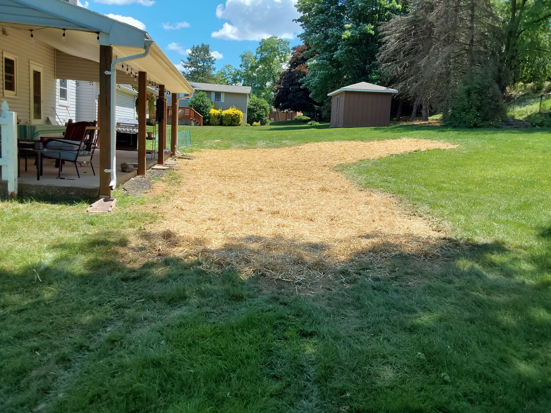 a house with a porch and a large lawn in front of it