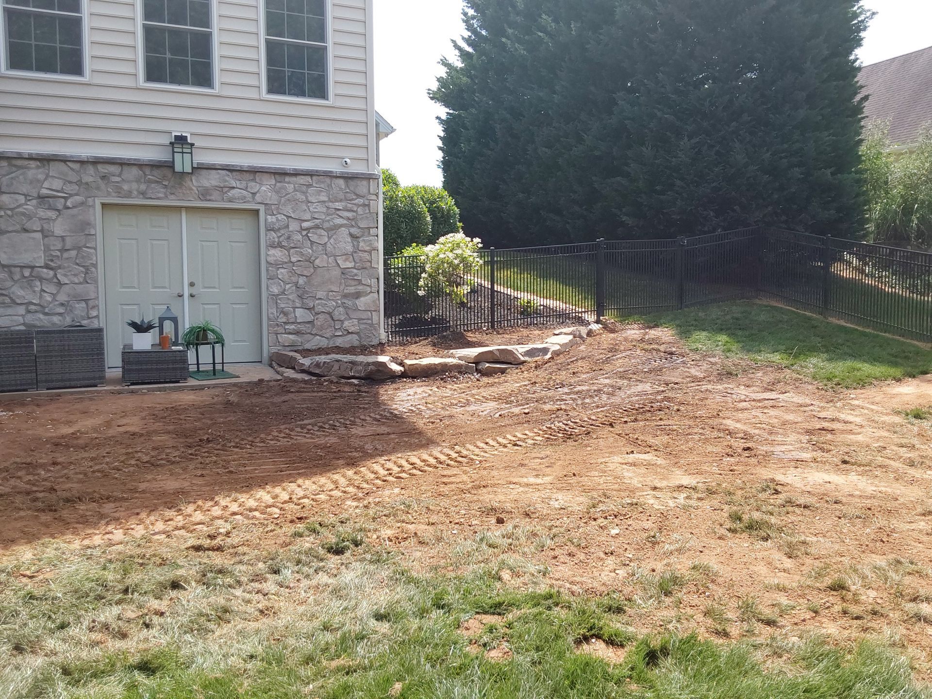 a house with a garage and a dirt driveway in front of it