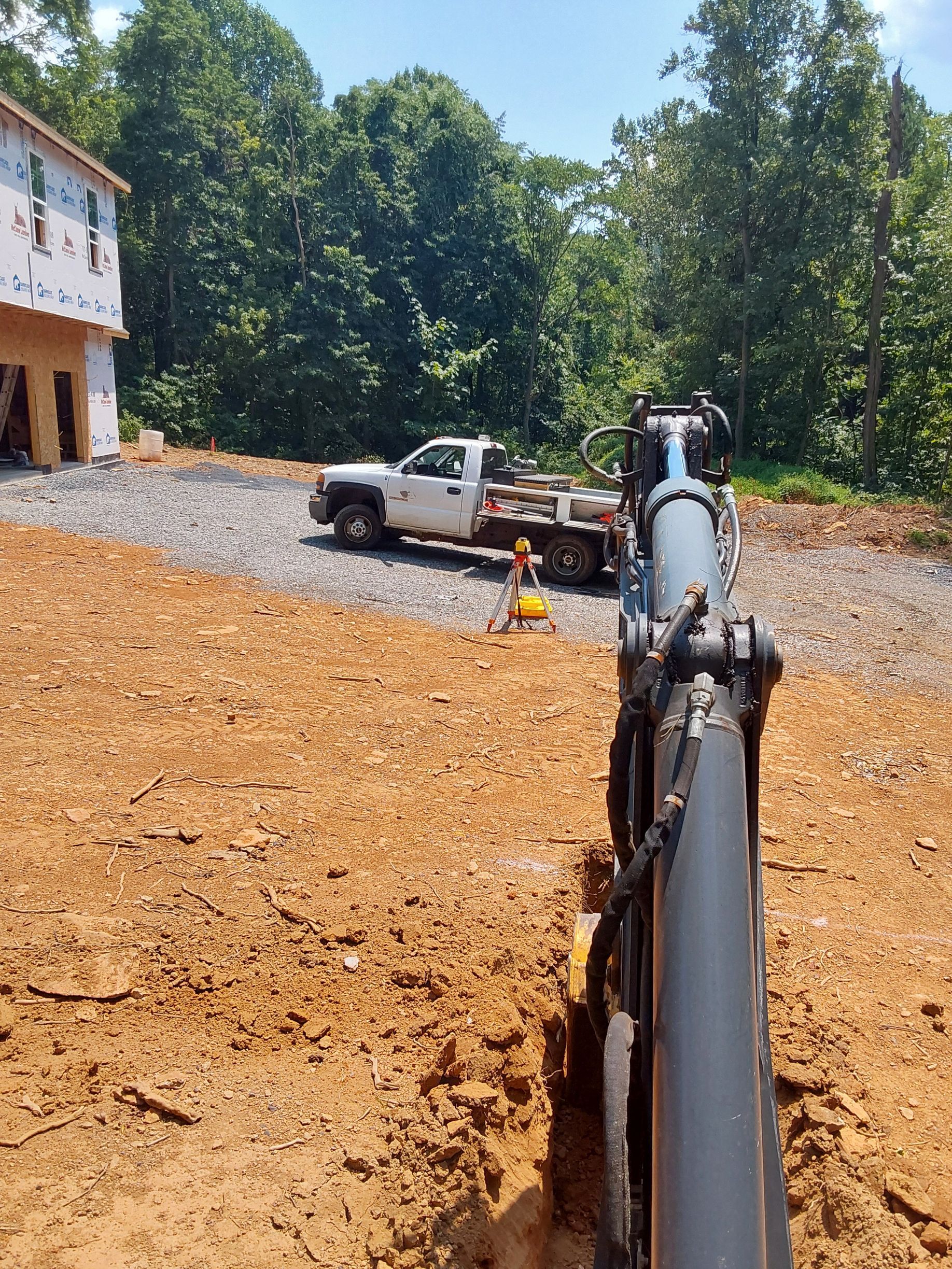 a white truck is parked in a dirt field next to a pipe