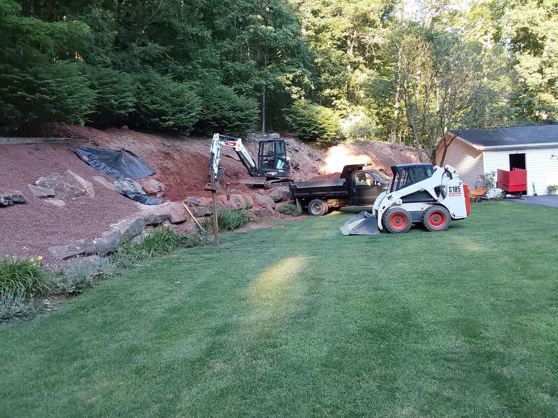 a bobcat is parked in the grass in front of a house