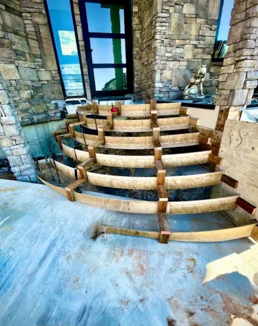 Stone steps under construction inside a room with stone walls and tall windows