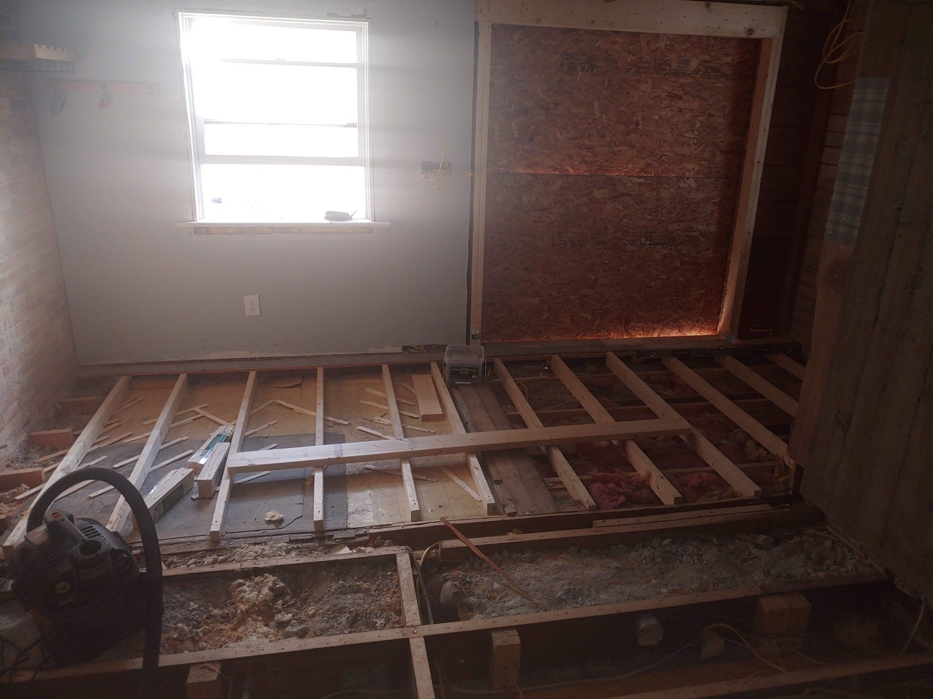 A room with a wooden floor and a window.