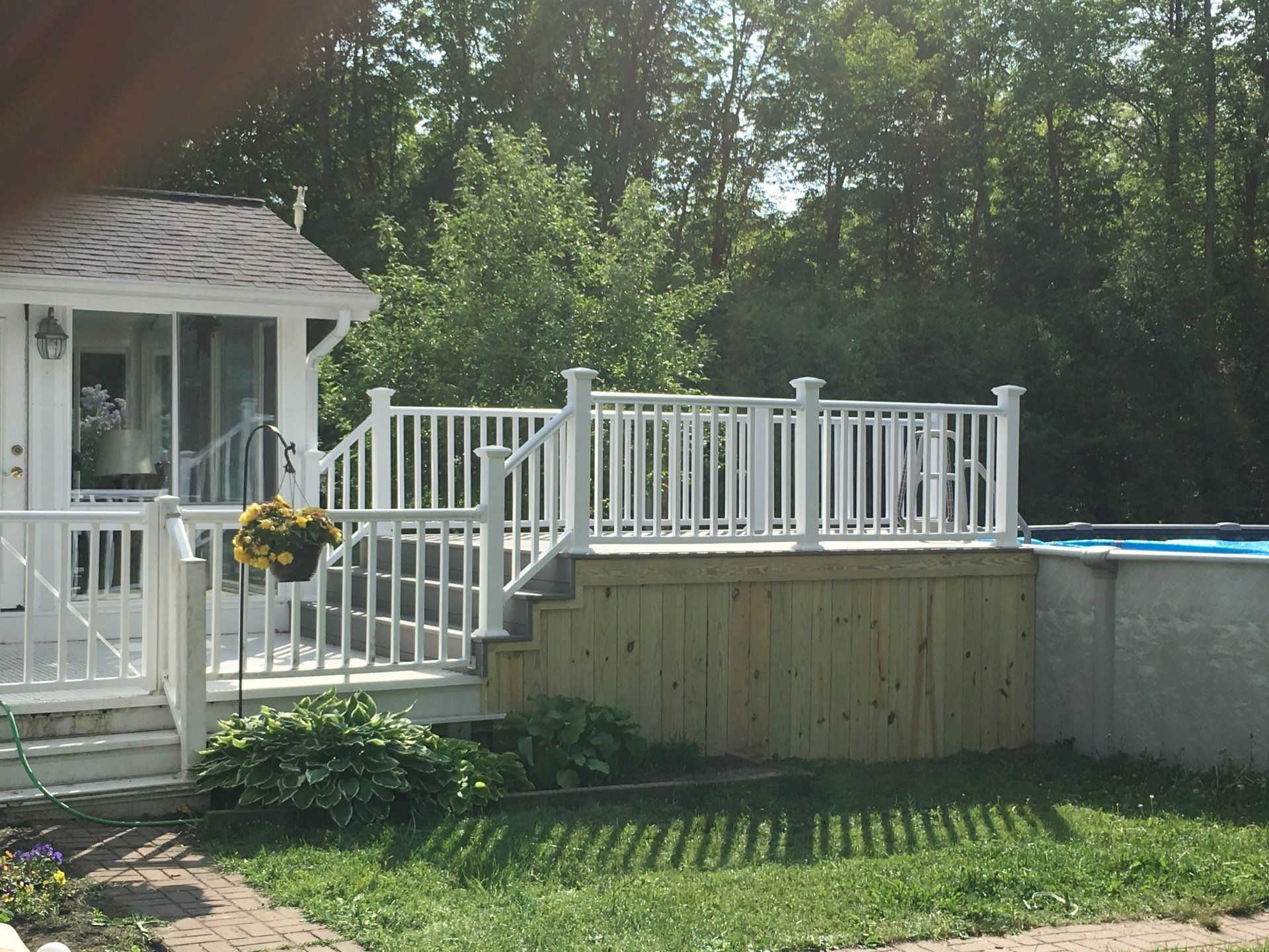 A white house with a deck overlooking a pool