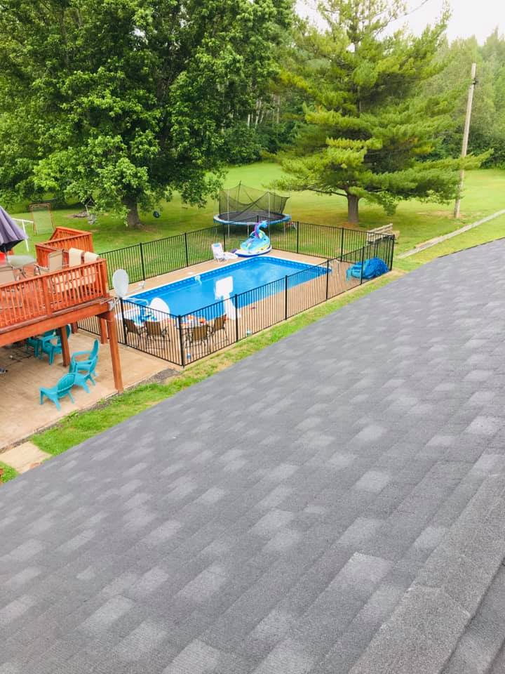 An aerial view of a backyard with a swimming pool and a deck.