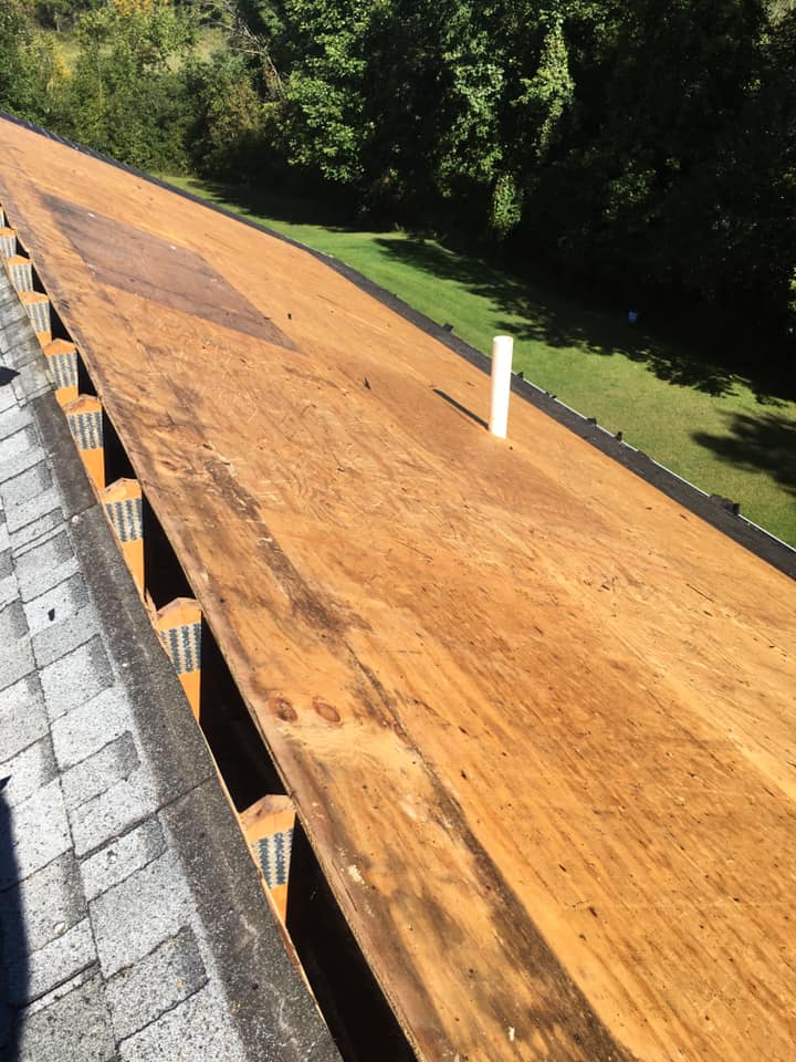The roof of a house is covered in wood and shingles.