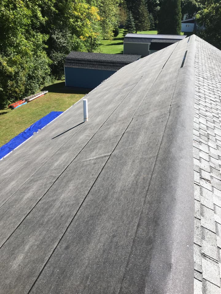 A close up of a roof with a chimney on it.