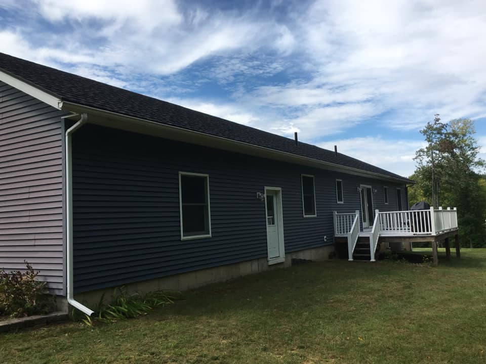 A blue house with a white deck and stairs