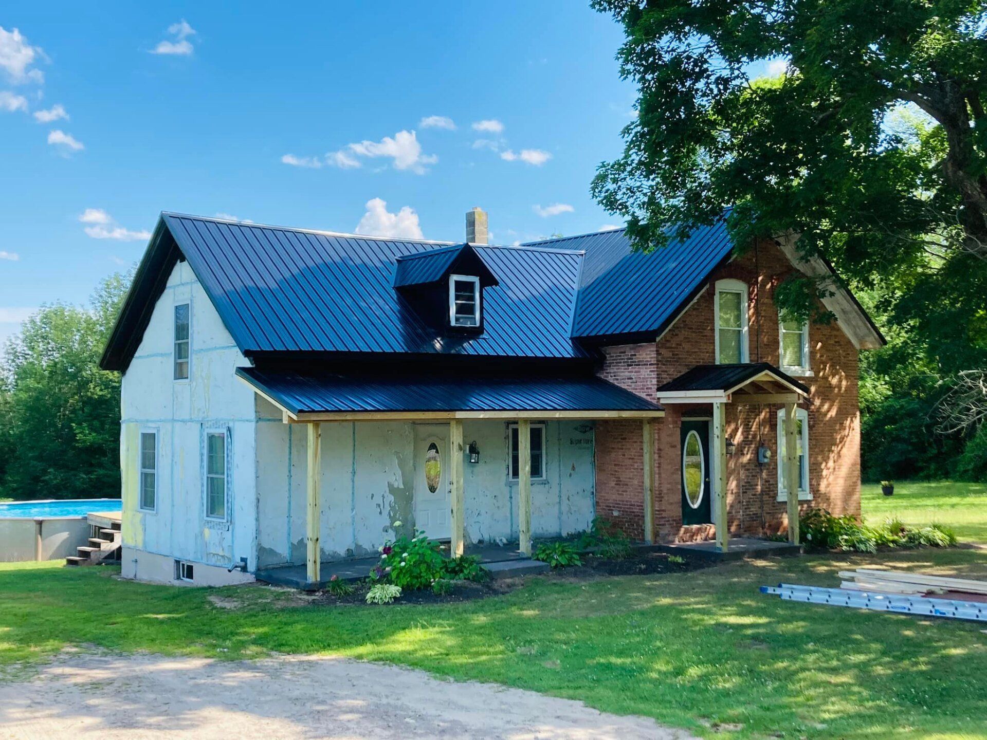 A white house with a black roof and a porch