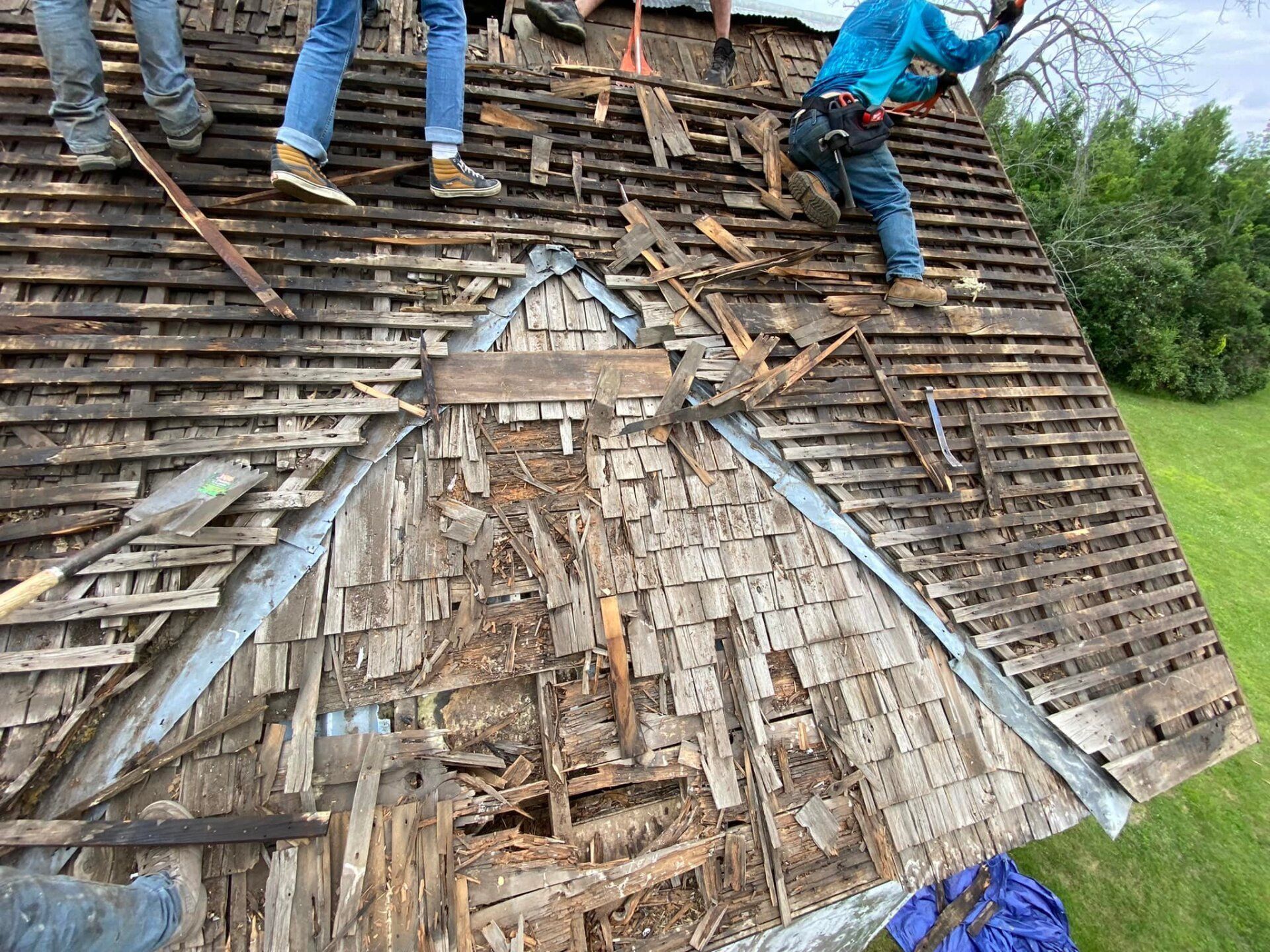 A group of people are working on a wooden roof.