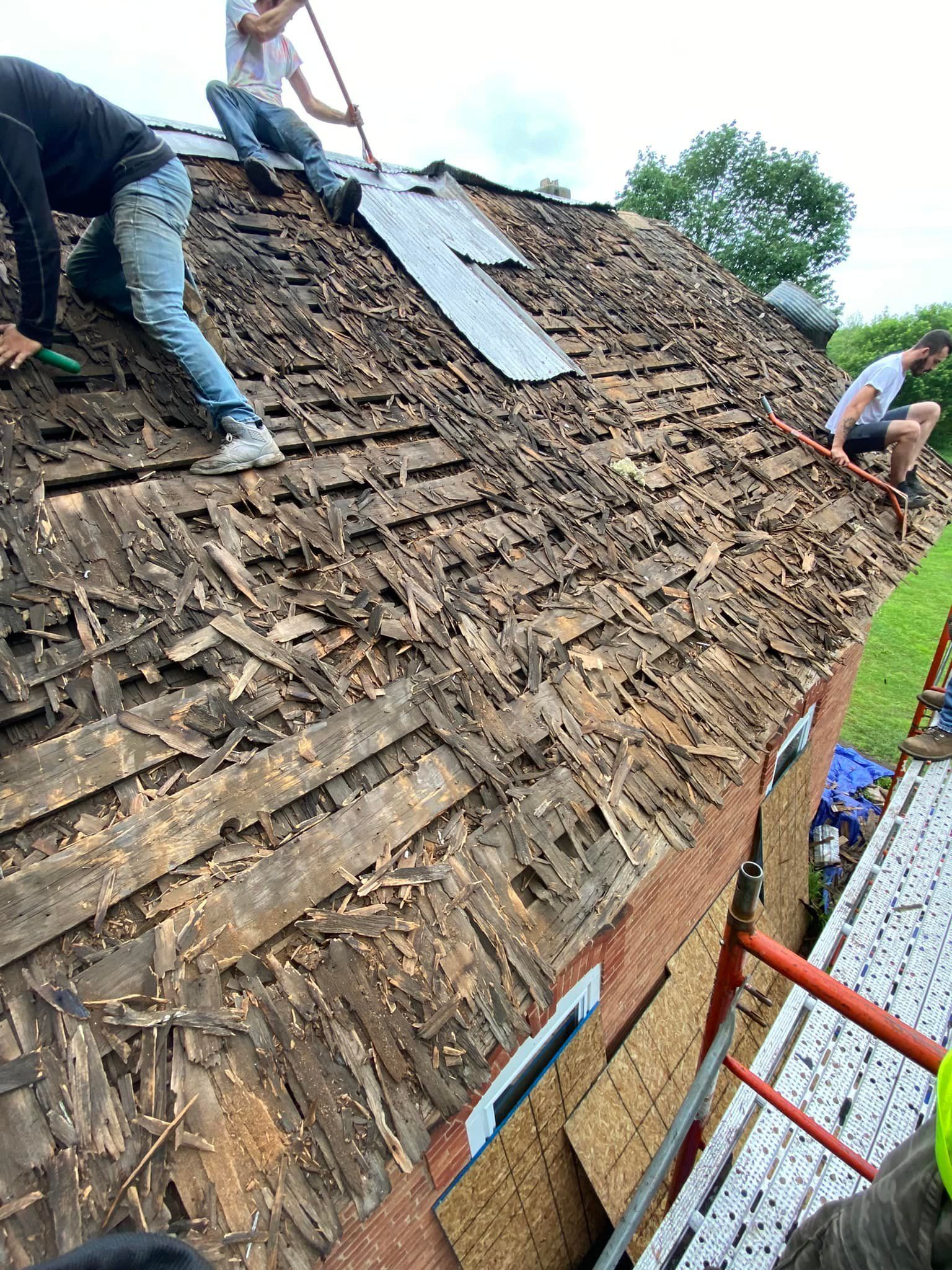 A group of people are working on a wooden roof.