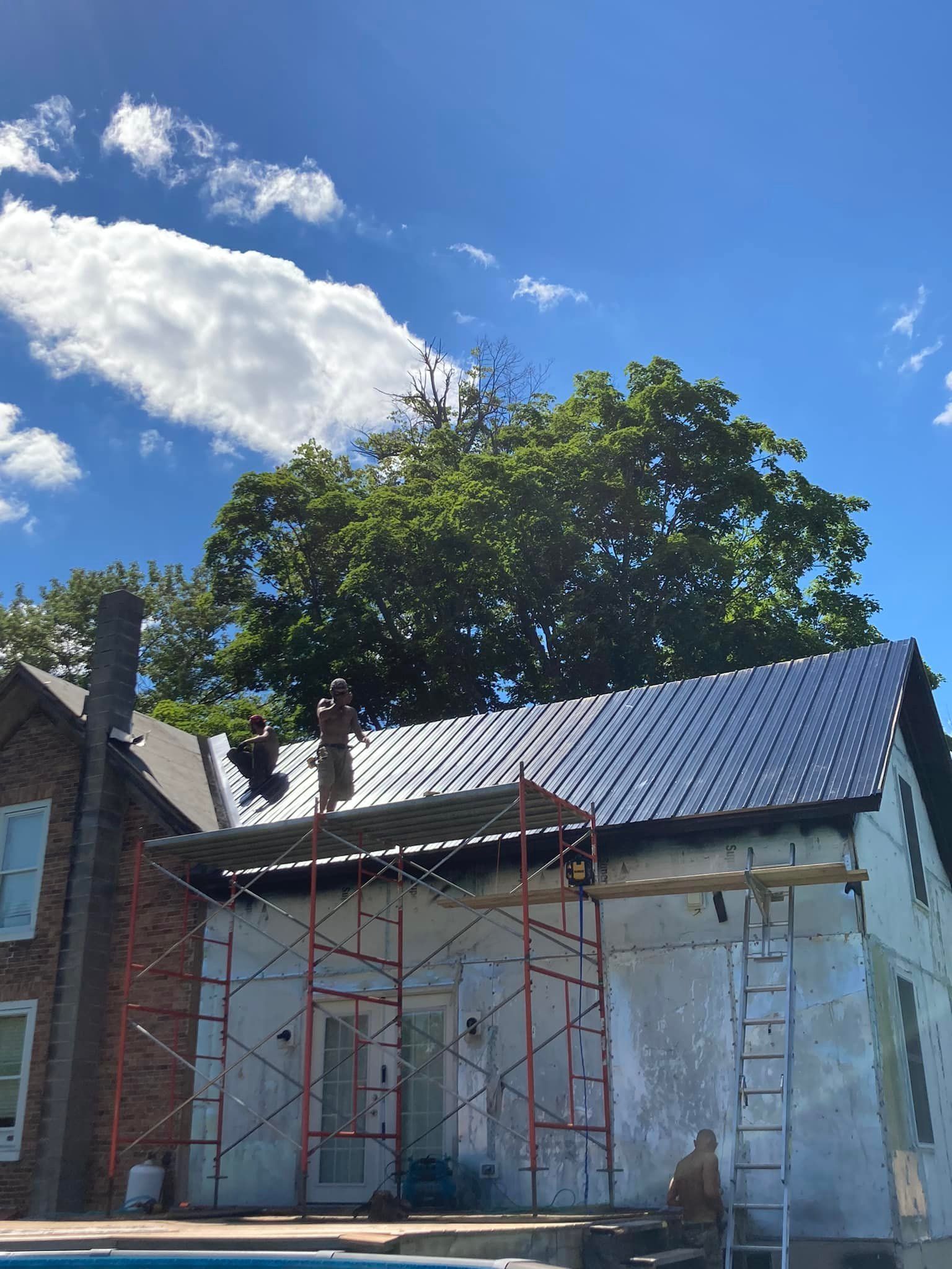 A house with a metal roof is being remodeled.