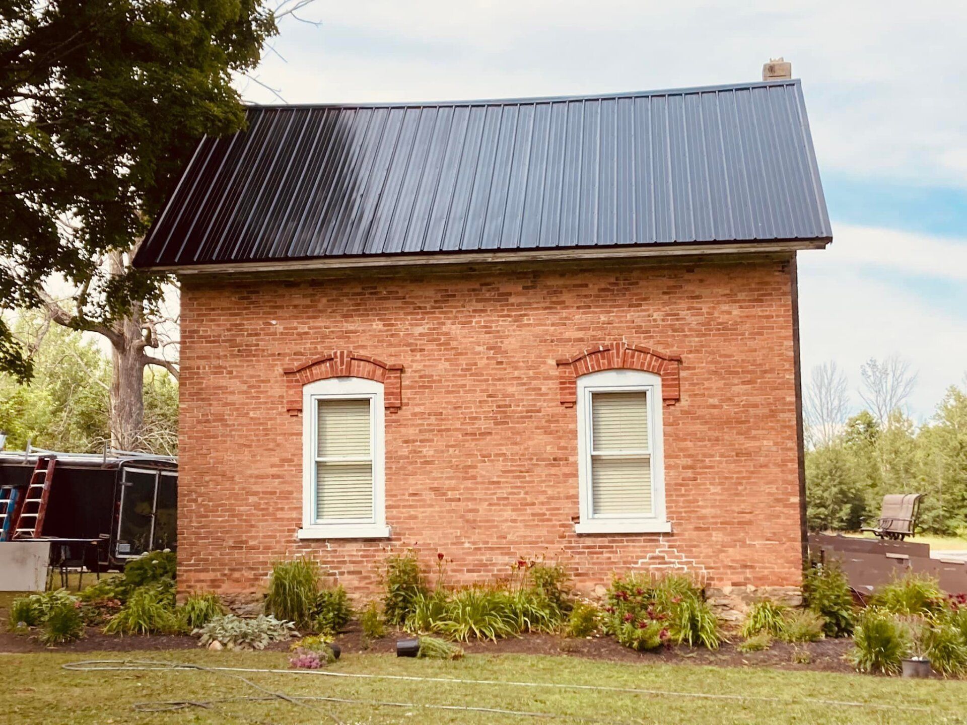 A brick house with a black roof and solar panels on it.