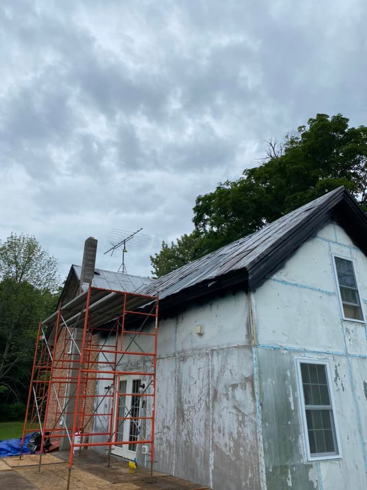A white house with a scaffolding on the side of it.
