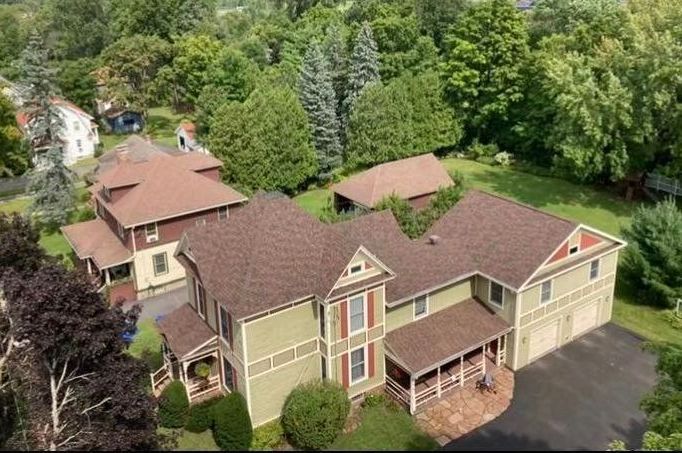 An aerial view of a large house surrounded by trees.