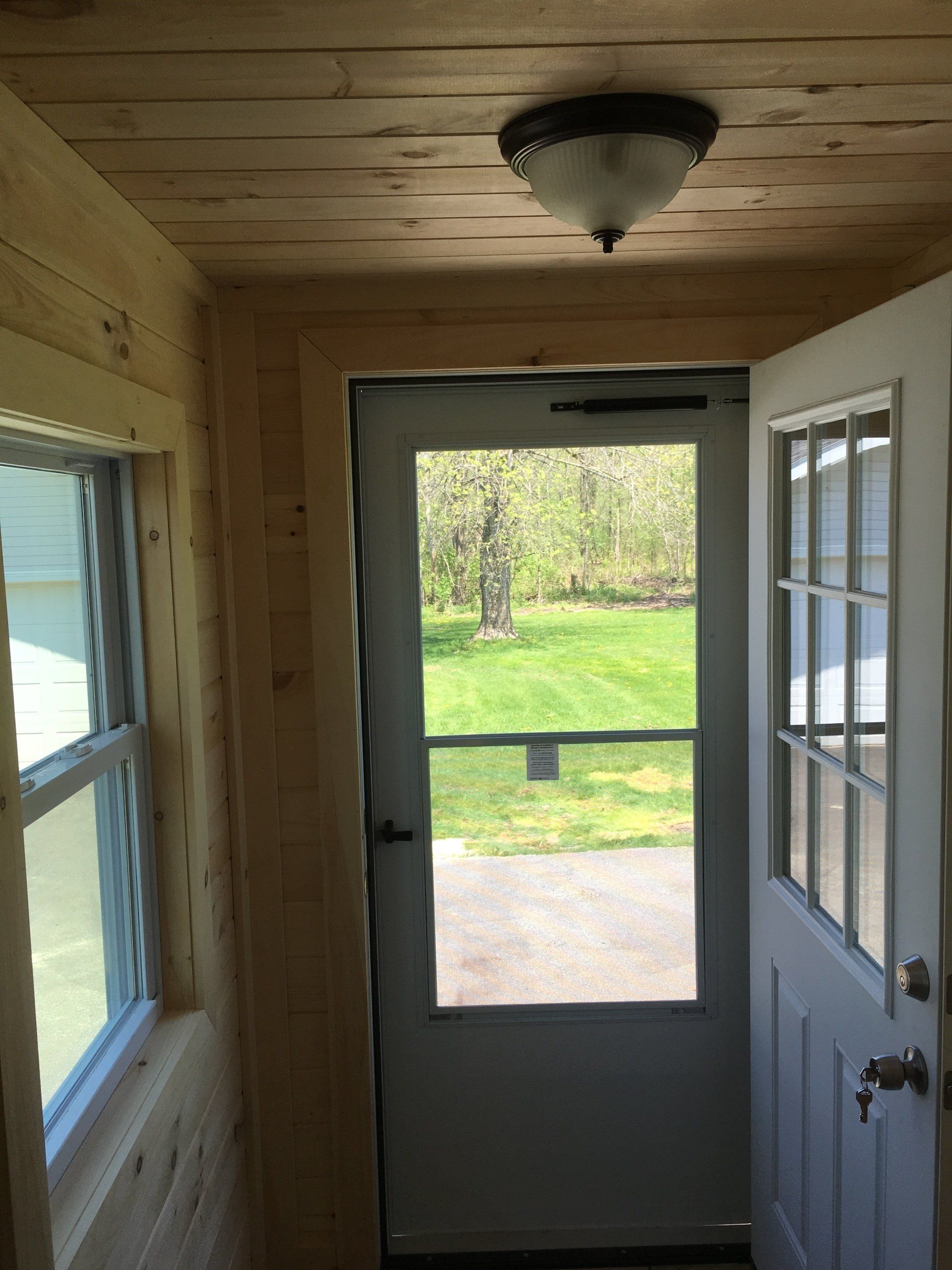 A hallway with a white door and a window
