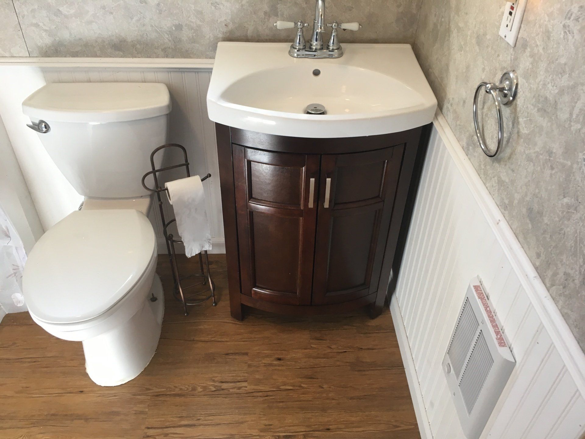 A bathroom with a toilet , sink and cabinet