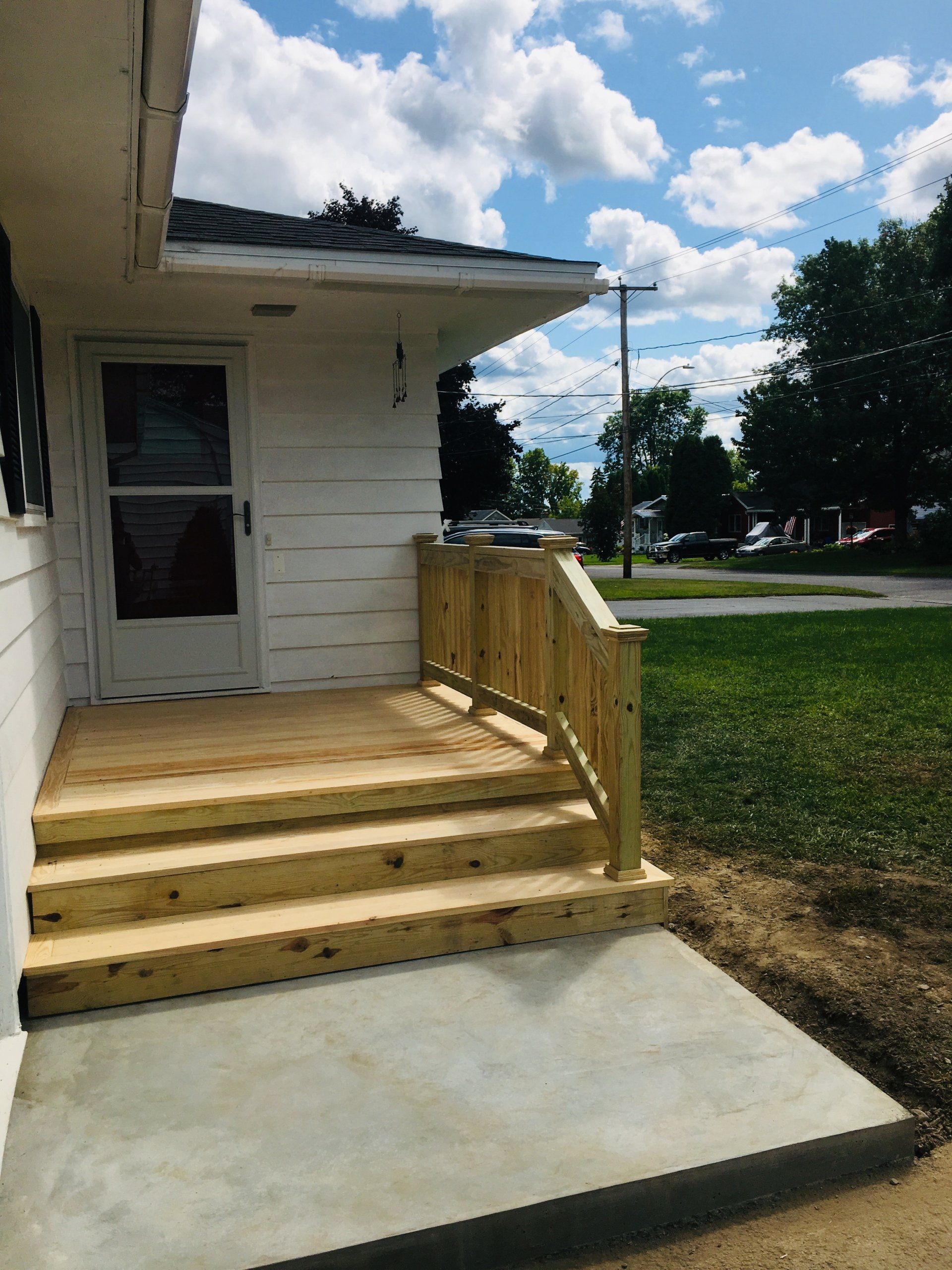 A white house with a wooden porch and stairs