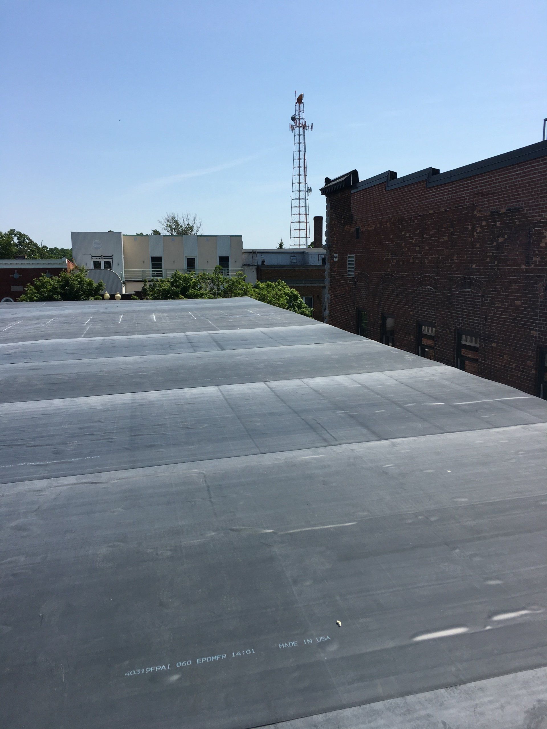 The roof of a building with a telephone tower in the background