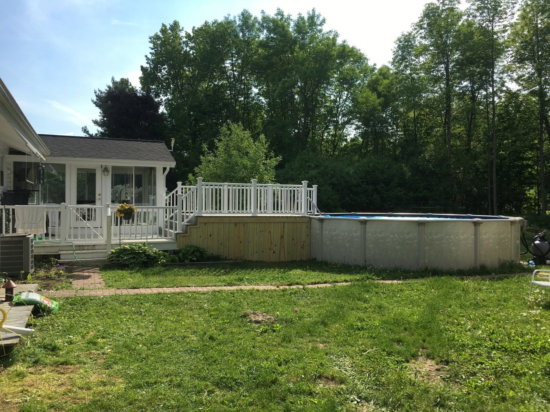 A large swimming pool is in the backyard of a house.