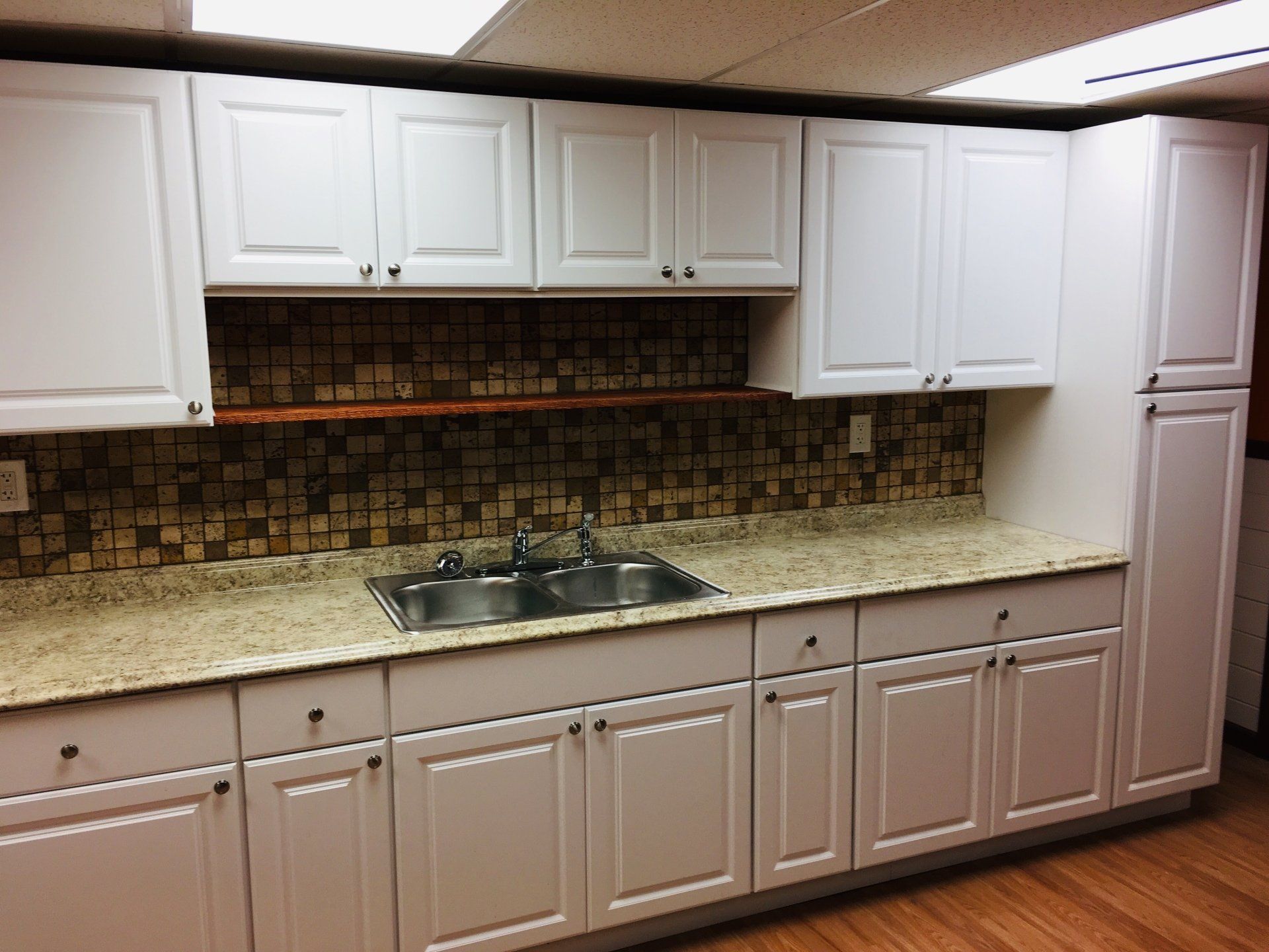 A kitchen with white cabinets and a sink