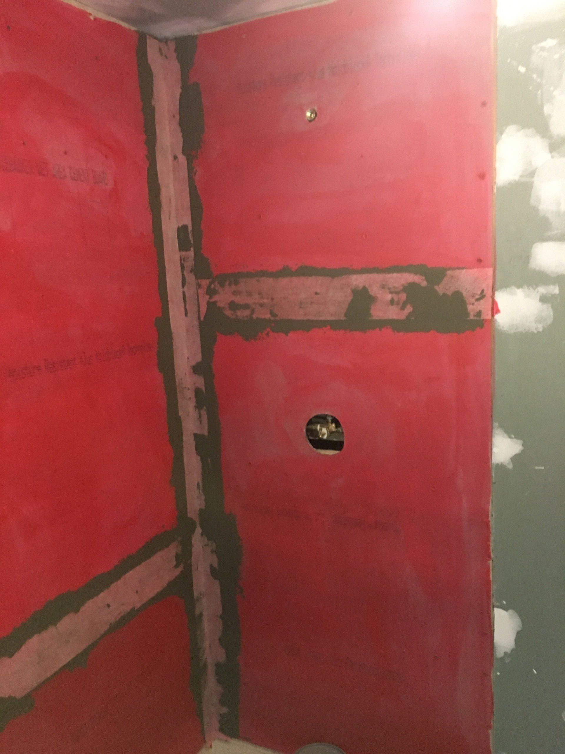 A bathroom with red walls and a black trim is being remodeled.