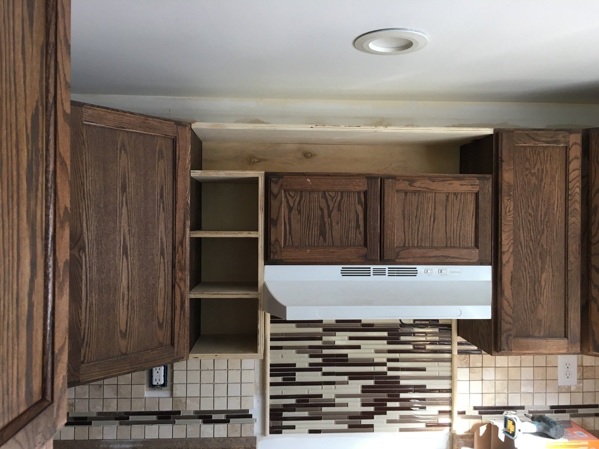 A kitchen with wooden cabinets and a stove top oven