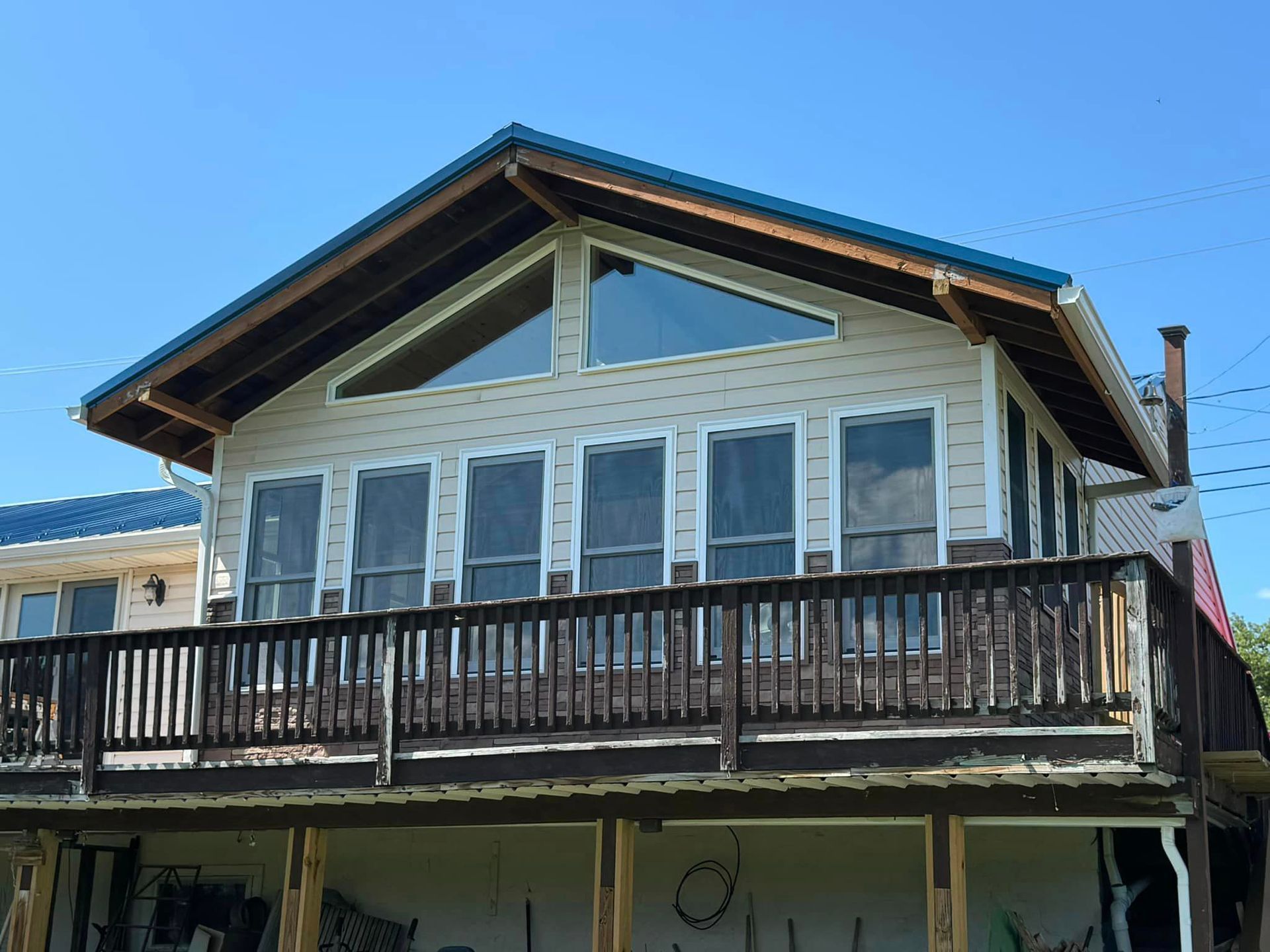 A house with a large deck and a blue roof