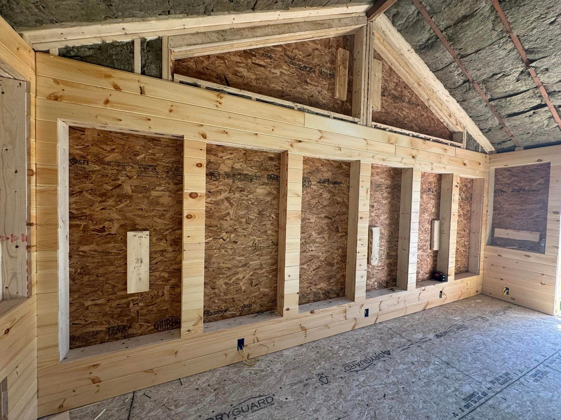 A room with a lot of wooden walls and a ceiling.