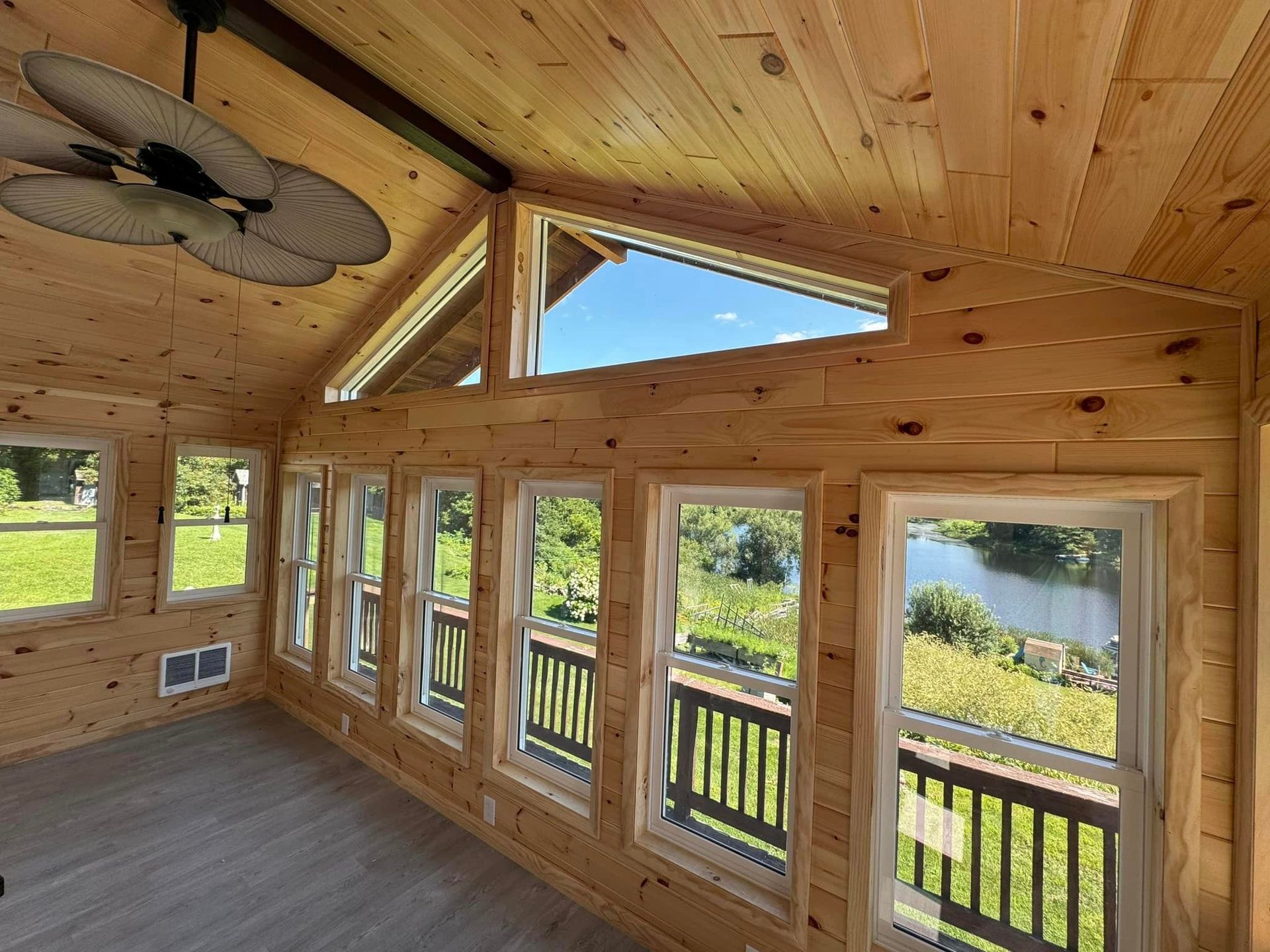A room with a lot of windows and a ceiling fan.