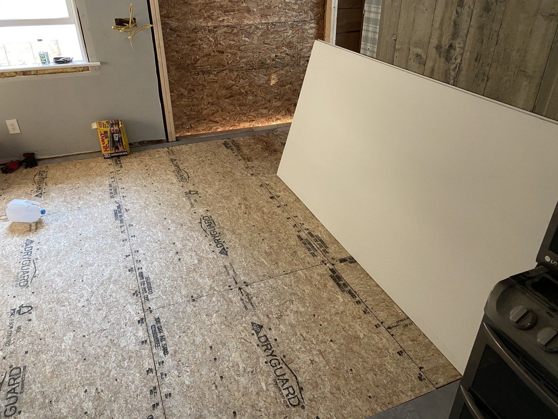 A room with a large piece of plywood on the floor.