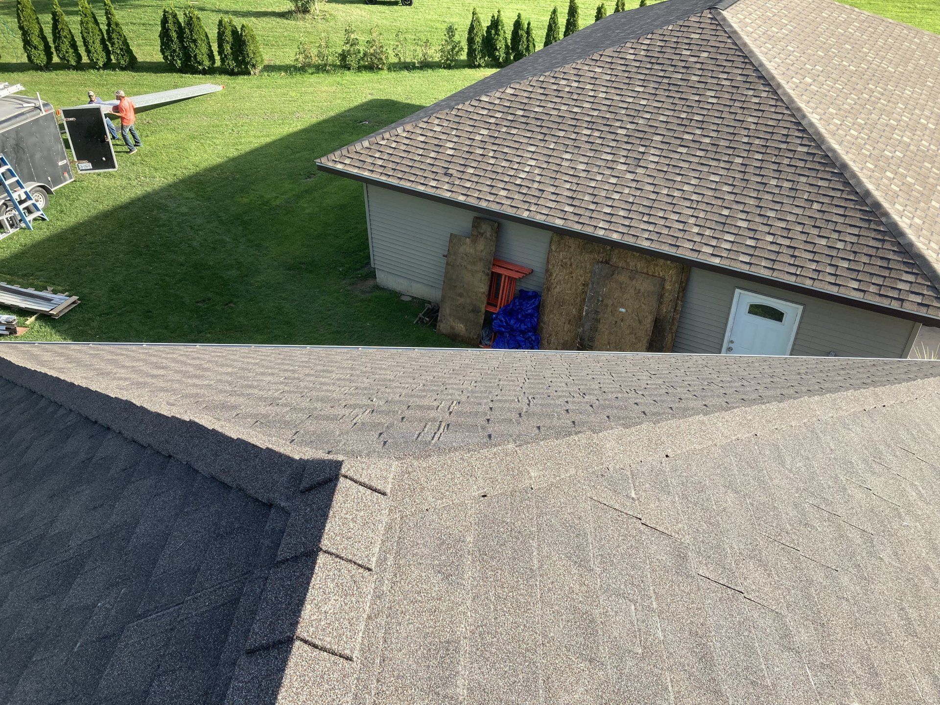 An aerial view of a roof of a house with a garage in the background.