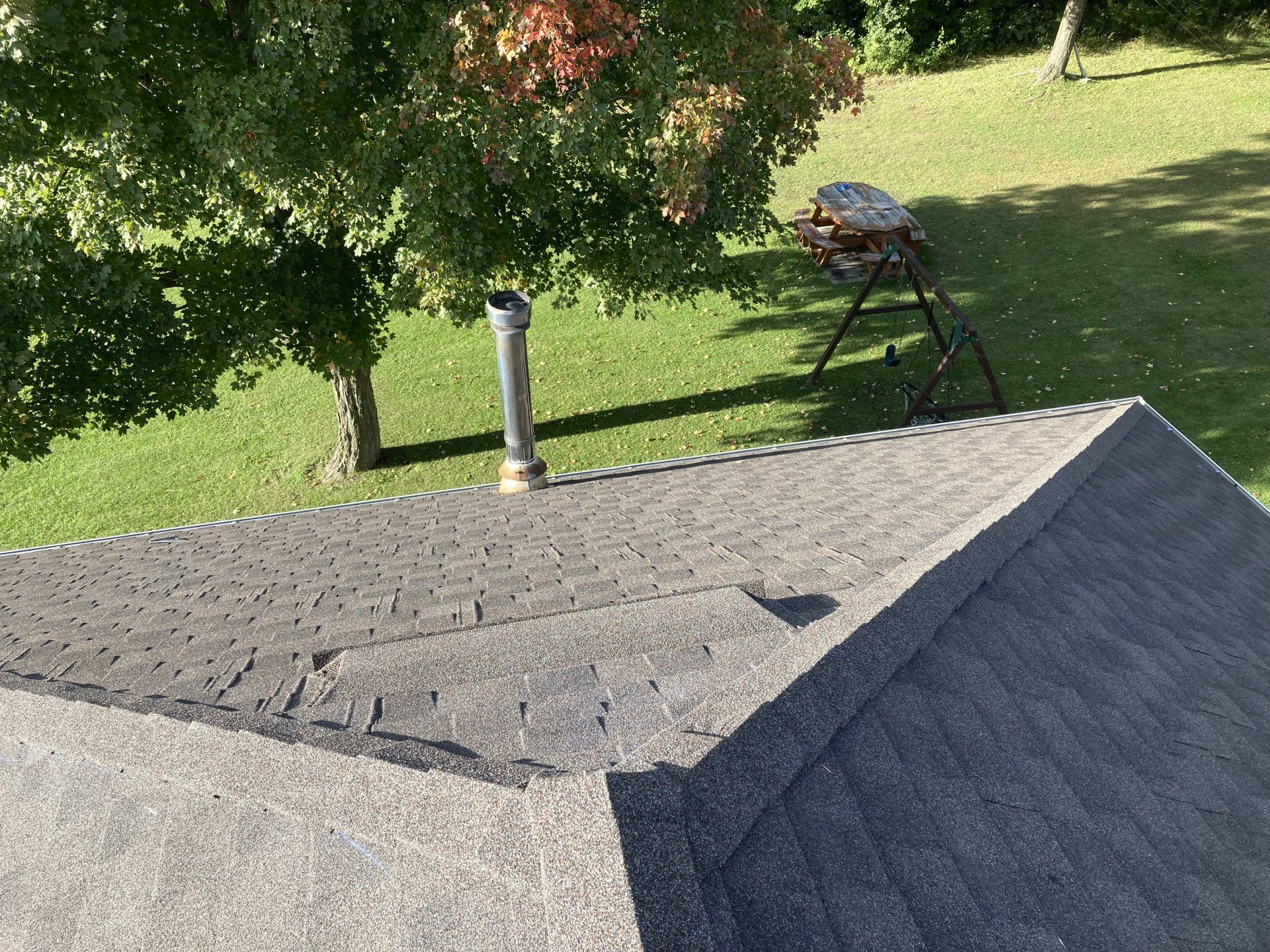 A roof with a chimney on it is sitting on top of a lush green lawn.