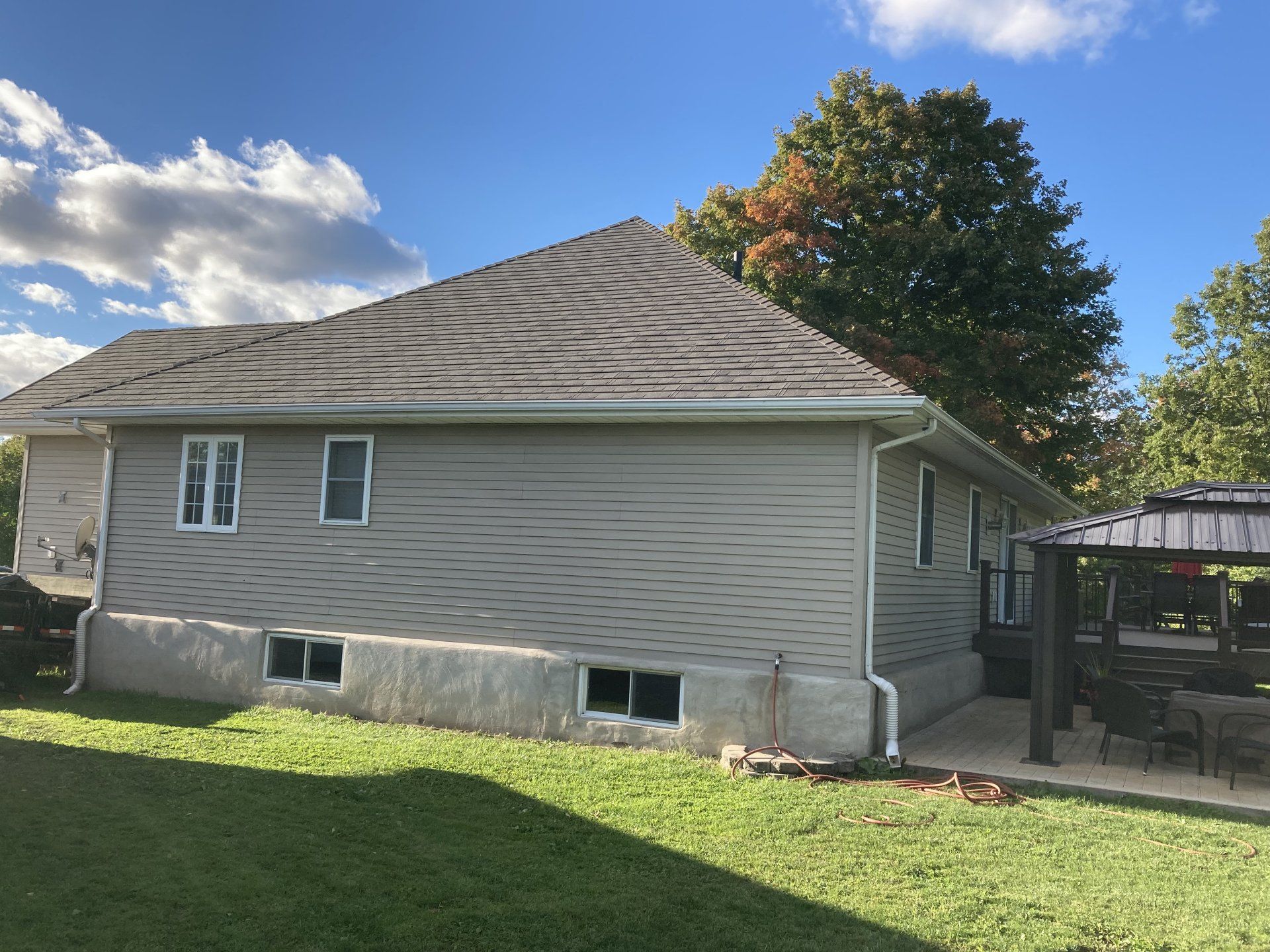 The back of a house with a pergola in the backyard.