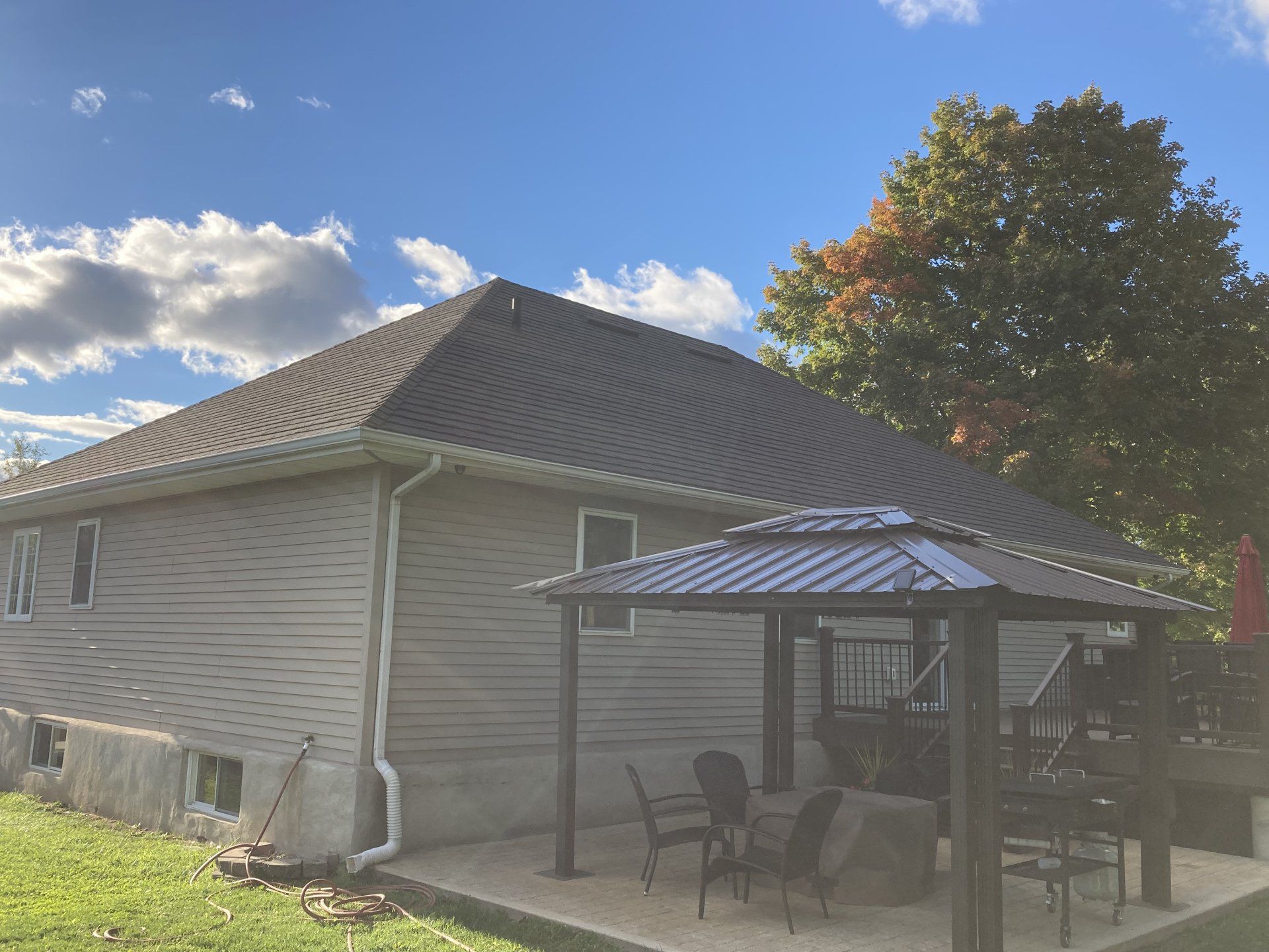 There is a gazebo in the backyard of a house.