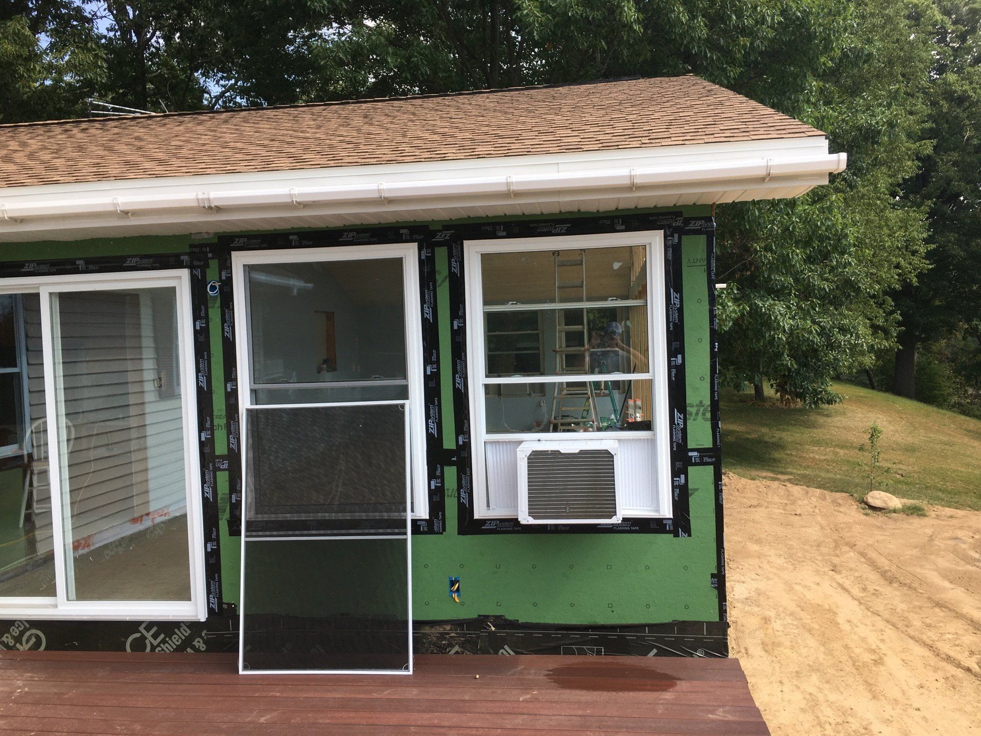 A small house with a screen door and sliding glass doors.