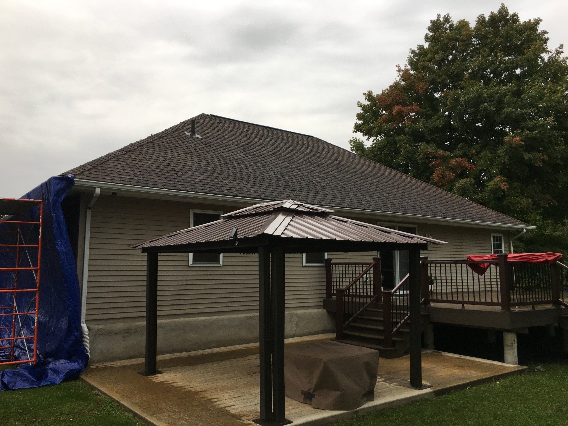 There is a gazebo in the backyard of a house.