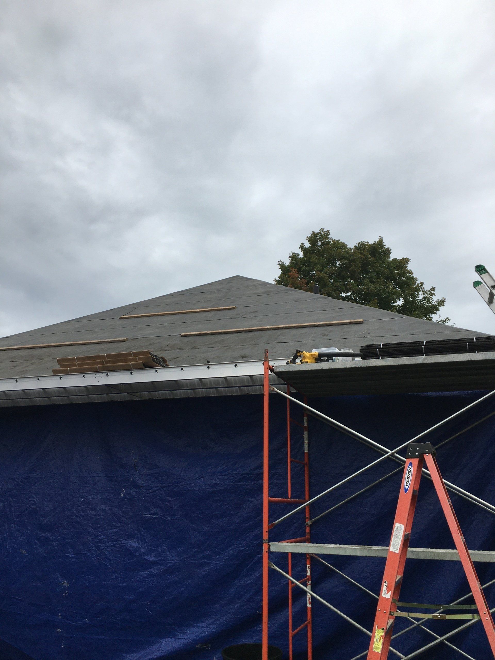 A blue tarp is covering the roof of a building