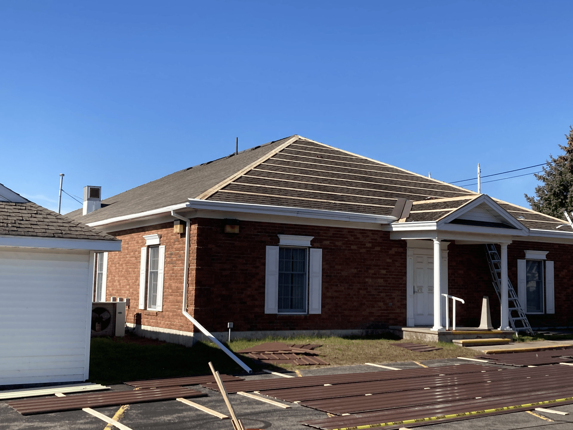 A brick house with a gray roof and white trim