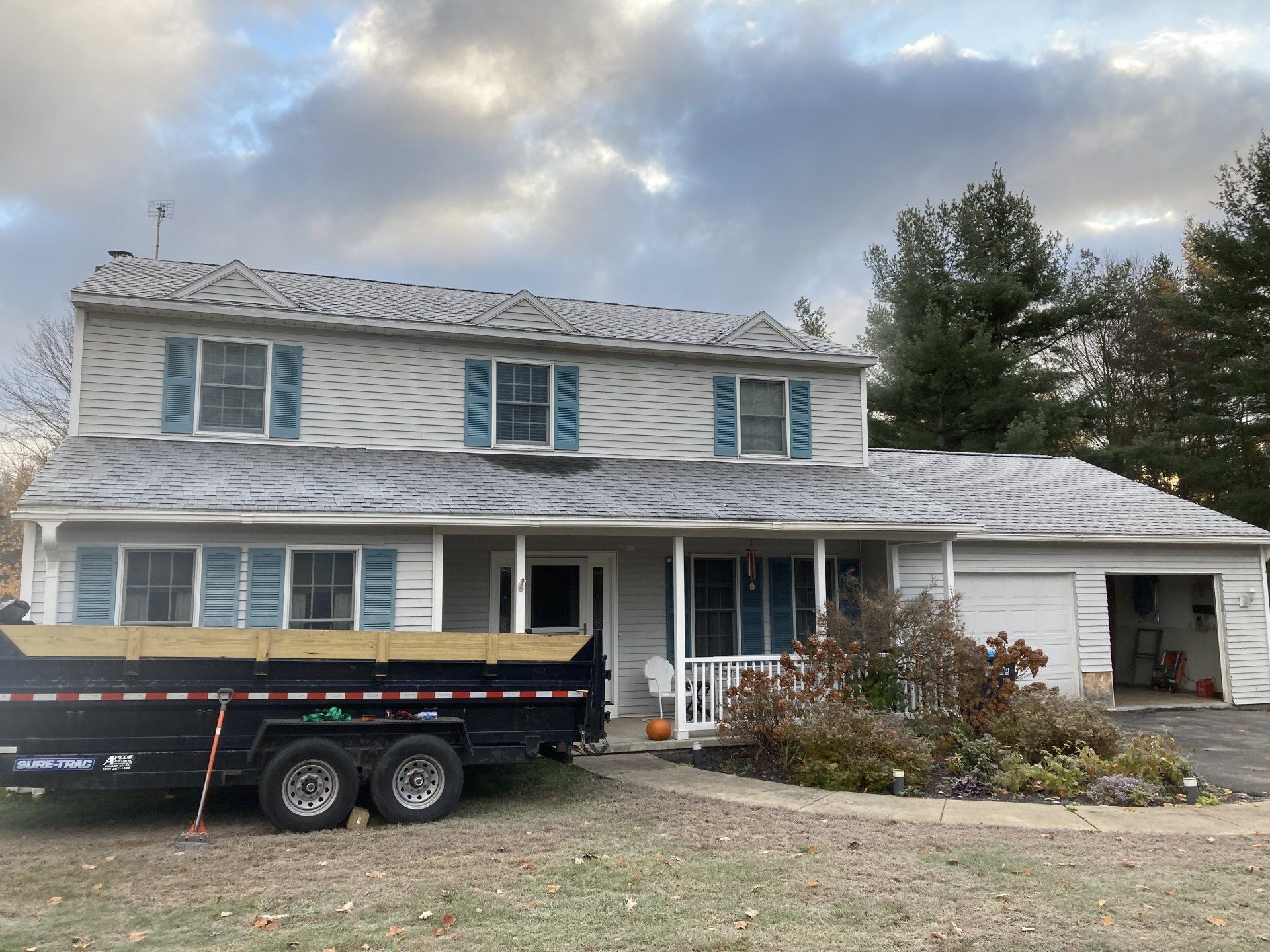 A dumpster is parked in front of a house.